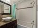 Bathroom with white tile, stylish vanity, and a tub with shower at 12420 W Atlantic Ave, Lakewood, CO 80228