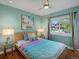 Bright bedroom features a ceiling fan, colorful accents, and a view of the home's exterior at 12420 W Atlantic Ave, Lakewood, CO 80228