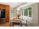 Sunlit dining area with hardwood floors, pendant lighting, and a large window overlooking the backyard at 12420 W Atlantic Ave, Lakewood, CO 80228