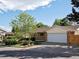 Charming single-Gathering home featuring a brick facade, lush landscaping, and an attached two-car garage at 12420 W Atlantic Ave, Lakewood, CO 80228