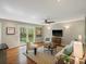 Cozy living room featuring hardwood floors, neutral paint, ceiling fan, and access to the backyard at 12420 W Atlantic Ave, Lakewood, CO 80228