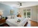 Relaxing main bedroom with a ceiling fan, light-blue wall, and sliding glass doors to the backyard at 12420 W Atlantic Ave, Lakewood, CO 80228