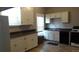 Well-lit kitchen with white cabinetry, modern appliances, and durable flooring at 4353 Wolff St, Denver, CO 80212