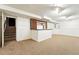 Finished basement featuring neutral carpet, a bar area with wine rack, and white walls with decorative panels at 10102 W Ida Ave # 214, Littleton, CO 80127