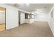 Spacious finished basement with neutral carpet, a bar area, and white wainscoting halfway up the wall at 10102 W Ida Ave # 214, Littleton, CO 80127