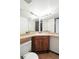 Bathroom featuring a vanity with dark wood cabinets, white sink, and large mirror with unique lighting at 10102 W Ida Ave # 214, Littleton, CO 80127
