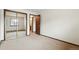 Bedroom featuring mirrored closet, neutral carpet, access to bathroom and light neutral walls at 10102 W Ida Ave # 214, Littleton, CO 80127