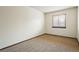 Empty bedroom with neutral carpet, crisp white walls, window and baseboard trim at 10102 W Ida Ave # 214, Littleton, CO 80127