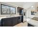 Bright kitchen boasts stainless steel appliances and dark cabinets with modern tile flooring at 10102 W Ida Ave # 214, Littleton, CO 80127