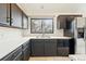 Well-lit kitchen featuring dark cabinetry, stainless steel appliances, and a window with natural light at 10102 W Ida Ave # 214, Littleton, CO 80127