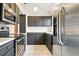 Modern kitchen featuring stainless steel appliances, gray cabinets, and bright lighting fixtures at 10102 W Ida Ave # 214, Littleton, CO 80127