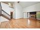 Open living room featuring a red brick fireplace, wood floors, and a staircase leading to the second level at 10102 W Ida Ave # 214, Littleton, CO 80127