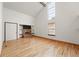 Bright living room featuring a red brick fireplace, wood floors, cathedral ceiling, and large windows at 10102 W Ida Ave # 214, Littleton, CO 80127