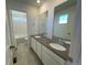 Bathroom with double vanity, large mirror, and adjacent tub shower at 5598 Wisteria Ave, Firestone, CO 80504