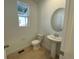 Clean bathroom with pedestal sink and oval mirror at 5598 Wisteria Ave, Firestone, CO 80504