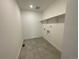 Laundry room with tile floor and built-in shelving at 5598 Wisteria Ave, Firestone, CO 80504