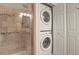 Modern bathroom features a tiled shower with glass door and stacked washer dryer for added convenience at 11085 Huron St # 1108, Northglenn, CO 80234