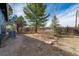 Gravel backyard area with mature landscaping and an air conditioning unit at 44626 Lariat Trl, Elizabeth, CO 80107