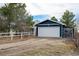 Detached garage features a large white door, side door, and a gravel driveway at 44626 Lariat Trl, Elizabeth, CO 80107
