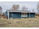 Exterior view of a blue outbuilding showing its rustic charm, including a set of small, multi-paned windows at 44626 Lariat Trl, Elizabeth, CO 80107