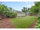 View of the lush, turfed backyard with a detached garage, privacy fence, and garden beds at 4438 S Elati St, Englewood, CO 80110