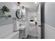 Finished basement bathroom featuring a vanity sink with mirror, bead board walls and view to bedroom at 4438 S Elati St, Englewood, CO 80110
