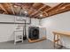 Unfinished basement laundry room with exposed ceiling, utility sink and gray washer and dryer at 4438 S Elati St, Englewood, CO 80110