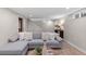 Basement living room featuring a gray sectional sofa, area rug and small storage area at 4438 S Elati St, Englewood, CO 80110