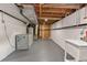 Unfinished basement with utility sink, open ceiling, and storage area at 4438 S Elati St, Englewood, CO 80110