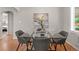 Modern dining area showcases a glass-top table, comfortable seating and hardwood floors at 4438 S Elati St, Englewood, CO 80110