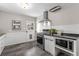 Charming kitchen featuring stainless steel appliances, white cabinets, and modern countertops at 4438 S Elati St, Englewood, CO 80110