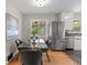 Eat-in kitchen with stainless steel appliances, modern cabinetry and a glass-top dining table at 4438 S Elati St, Englewood, CO 80110