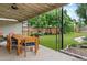 Outdoor patio with a dining table and chairs overlooking the landscaped backyard and lovely green lawn at 4438 S Elati St, Englewood, CO 80110