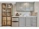 Finished basement bar area featuring gray cabinetry, wine storage, and a mini fridge at 901 Sage Sparrow Cir, Highlands Ranch, CO 80129