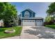 Charming two-story home with a three car garage, manicured lawn and a flower garden in the front yard at 901 Sage Sparrow Cir, Highlands Ranch, CO 80129