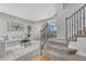 Bright living room featuring a neutral color palette, plush seating, and staircase with ornate iron railings at 901 Sage Sparrow Cir, Highlands Ranch, CO 80129