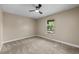 Bright bedroom featuring neutral walls and carpet, a ceiling fan, and a window with outdoor views at 12142 Melody Dr # 301, Denver, CO 80234