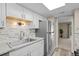 Bright kitchen with stainless steel fridge, granite counters and mosaic backsplash at 12142 Melody Dr # 301, Denver, CO 80234