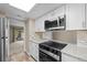 Updated kitchen featuring stainless steel appliances, granite counters and white cabinetry at 12142 Melody Dr # 301, Denver, CO 80234