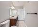 Neutral toned bathroom featuring a wood vanity, tile floors, and a large mirror at 2705 S Danube Way # 306, Aurora, CO 80013