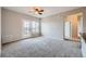 Open-concept living room with a ceiling fan, plush carpet, and door to outside at 2705 S Danube Way # 306, Aurora, CO 80013