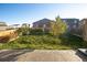 Spacious backyard with green grass and trees, fenced for privacy, and patio area at 1908 Homestead Dr, Fort Lupton, CO 80621