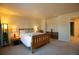 Comfortable bedroom with a queen-size bed, neutral carpet, and soft, warm lighting at 1908 Homestead Dr, Fort Lupton, CO 80621