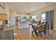 Bright dining area featuring wood floors, contemporary table, and sliding glass door to the backyard at 1908 Homestead Dr, Fort Lupton, CO 80621