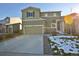 Two-story home with attached garage, a concrete driveway, and landscaping with melting snow at 1908 Homestead Dr, Fort Lupton, CO 80621