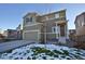 Two-story home with an attached garage and a well-manicured lawn and snowy landscaping at 1908 Homestead Dr, Fort Lupton, CO 80621