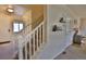 Well-lit entry featuring carpeted stairs, white railing, and view into the main living area at 1908 Homestead Dr, Fort Lupton, CO 80621