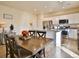 Bright kitchen and dining area featuring a central island, stainless appliances, and a wooden dining table at 1908 Homestead Dr, Fort Lupton, CO 80621