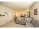 Open living room area leading into the kitchen, with a comfortable sofa and plenty of light at 1908 Homestead Dr, Fort Lupton, CO 80621