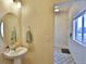 Cozy powder room with pedestal sink, oval mirror, and a view into the foyer area at 1908 Homestead Dr, Fort Lupton, CO 80621